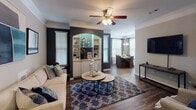 Located at 2430 Garden Hill Dr in Raleigh, NC, this single-story home offers a thoughtfully designed layout with a blend of classic architectural details and functional living spaces. The entry corridor introduces decorative columns with crown molding and arched built-in shelving, setting a refined tone that carries throughout the home.

The living room serves as a central gathering space, featuring crown molding, a ceiling fan, and dark hardwood flooring. A bold accent wall frames a lighted arched built-in cabinet, adding both character and display space. This area flows naturally into the dining room, which is illuminated by a chandelier and benefits from multiple windows that bring in natural light.

The kitchen is equipped with white cabinetry, stainless steel appliances including a range and refrigerator, and light hardwood flooring. Track lighting and a window above the sink contribute to a bright, functional workspace.

The bedrooms are carpeted and include ceiling fans, ample natural light from multiple windows, and generous closet space. One bedroom features a walk-in closet, while another includes a built-in window seat. The bathrooms offer wood-look flooring, white vanity cabinetry, and well-lit mirror areas, providing clean and practical finishes throughout.