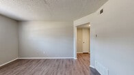 Located at 1009 N Cottage St in Independence, Missouri, this two-bedroom, one-bathroom unit offers a practical and efficient single-floor layout. The living room features wood-look laminate flooring and neutral gray walls, with a paneled door and a window that brings in natural light, creating a clean and open feel. A hallway connects the main living areas to the rest of the unit seamlessly.

The kitchen is equipped with white appliances including a refrigerator, dishwasher, and electric range, complemented by wood-trimmed white cabinetry, a double sink, and laminate countertops. Wood-look flooring continues throughout the kitchen, which also features a secondary door with decorative lattice window detailing.

Both bedrooms are carpeted and feature neutral walls, textured ceilings, and windows with blinds that allow for natural light. The primary bedroom includes a mirrored sliding closet door, adding a sense of depth to the room. The second bedroom is similarly sized and bright.

The bathroom is straightforward and functional, featuring a tiled tub and shower combination with a window above for ventilation and light. Throughout the unit, consistent textures and a neutral color palette create a cohesive and understated living environment well-suited for comfortable everyday living.