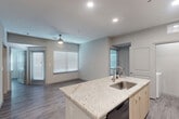 Located at 12752 N Houston Rosslyn Road in Houston, TX, this single-story 2-bedroom, 2-bathroom home offers a clean, modern aesthetic with consistent wood-look flooring and a neutral color palette throughout. The open-concept living, dining, and kitchen area serves as the heart of the home, bathed in natural light from multiple windows dressed with white blinds. A ceiling fan adds comfort to the airy living space, which connects directly to the kitchen. The kitchen is well-equipped with light wood cabinetry, granite-style countertops, a stainless steel sink set into a center island, and black appliances including a range, microwave, and refrigerator. Both bedrooms are comfortably sized, each featuring ceiling fans, natural light from dual windows, and wood-look flooring. The primary bedroom connects to its own bathroom, which includes a granite-topped vanity with modern cabinetry. Both bathrooms are finished with large-format tile surrounds in the tub/shower combinations. Four closets provide generous storage, including walk-in wire-shelving systems. A dedicated laundry area and multiple hallways complete the functional layout of this thoughtfully designed home.