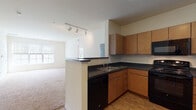 Located at 400 Blake St in New Haven, CT, this single-floor residence offers a well-designed layout that balances functionality and comfort. The kitchen is a standout feature, equipped with warm maple cabinetry, dark granite-style countertops, and a full suite of black appliances including a refrigerator, range, microwave, and dishwasher. Wood-style flooring runs throughout the kitchen, which opens to a bright living area via a peninsula counter. The living space is generously sized, featuring plush wall-to-wall carpeting, track lighting, and windows that allow natural light to fill the room. Multiple bedrooms continue the carpeted aesthetic, each offering neutral tones, windows with exterior views, and ample wall space. One bedroom includes access to a spacious walk-in closet outfitted with wire shelving and hanging rods. The bathroom is well-appointed with wood-style flooring, a wood-toned vanity with dark countertop, a large mirror with overhead lighting, and a tiled tub-shower combination. Throughout the unit, the clean, neutral color palette and consistent finishes create a cohesive and move-in-ready atmosphere suited for a variety of lifestyles.