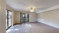 Located at 1750 20th Avenue Dr NE in Hickory, NC, this two-floor residence offers a well-organized layout with a blend of functional design and comfortable living spaces. The main living area features durable hardwood-style flooring that flows throughout, complemented by neutral-toned walls and a textured ceiling. A ceiling fan with integrated lighting adds both style and practicality, while large sliding glass doors open to an outdoor area, filling the room with natural light and providing views of the surrounding greenery. Adjacent to the living area is a wet bar nook with white cabinetry and a dark countertop, adding a convenient entertaining feature. The kitchen is equipped with stainless steel appliances, including a refrigerator, electric range, and dishwasher, all set against white cabinetry and light countertops with hardwood-style flooring. The bedrooms are carpeted for comfort and feature ceiling fans, generous closet space, and windows that invite natural light. The bathroom includes a wide vanity with white cabinetry, a large mirror, and a separate shower area. An attached garage provides ample room for vehicles or additional storage, completing this practical and comfortable Hickory home.