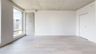 Located at 900 Rue Saint-Jacques in the heart of Montréal, this efficiently designed unit offers a thoughtful single-floor layout that maximizes every square foot. The open living area is anchored by light-toned hardwood flooring and striking exposed concrete ceilings and columns, lending the space an industrial-modern character that is both stylish and distinctive. Large floor-to-ceiling windows flood the living area with abundant natural light while framing impressive views of the Montréal skyline, enhancing the sense of openness throughout.

The galley-style kitchen is well-equipped with stainless steel appliances, including a range and dishwasher, complemented by two-toned cabinetry featuring natural wood lower cabinets and crisp white uppers. Dark stone countertops and a classic white subway tile backsplash add a refined finishing touch, while recessed lighting ensures a bright and functional workspace.

The bathroom is finished to a high standard, showcasing warm-toned large-format floor tiles, a wood-accented vanity with a dark countertop and gold hardware, and a glass-enclosed walk-in shower with white tile surround. Clean white walls throughout maintain a cohesive and contemporary aesthetic, making this a polished and practical urban residence in one of Montréal's vibrant downtown neighbourhoods.