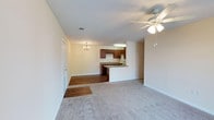 This single-floor residence at Tanyard offers a functional and well-organized layout designed for comfortable everyday living. The open-concept living and dining area forms the heart of the home, with plush wall-to-wall carpeting in the living space and wood-look flooring in the dining area. A ceiling fan with integrated lighting serves the living room, while a classic chandelier adds a decorative touch above the dining space. A sliding glass door in the living room leads to an outdoor balcony, allowing natural light to filter into the space.

The kitchen is designed in a galley configuration, featuring rich dark wood cabinetry lining both sides, stone-toned countertops, and wood-look flooring. Appliances include an electric range, built-in microwave, dishwasher, and refrigerator, with a double-basin sink completing the setup. A peninsula counter connects the kitchen to the dining area, offering additional workspace and casual seating potential.

The bedrooms are carpeted and equipped with ceiling fans and windows that bring in natural light. Two bathrooms serve the unit, each featuring a tub-shower combination, toilet, and a vanity with ample counter space. Throughout, neutral wall tones and clean white trim create a bright, cohesive atmosphere.