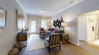 Located at 11100 Beckstone Way in Wake Forest, NC, this single-story residence offers a well-appointed layout designed for comfortable everyday living. Crown molding throughout the main living areas adds a refined architectural touch, while durable wood-look flooring unifies the living room, dining area, and kitchen.

The living room is generously sized, featuring large windows and a glass-paneled door that invite abundant natural light. The dining area accommodates a round table with ample surrounding space, complemented by a pendant light fixture and crown molding detailing.

The kitchen is outfitted with dark cabinetry, dark appliances including a range, microwave, and refrigerator, granite-style countertops, and a dedicated walk-in pantry with built-in shelving for additional storage.

The bedrooms offer plush carpeting, natural light from well-positioned windows, and closet space. The primary bathroom features a dual-sink vanity with dark cabinetry and granite-style countertops, tile flooring, and a walk-in linen closet. The secondary bathroom includes a tub-shower combination, a single-sink vanity with matching dark cabinetry and granite-style countertops, and tile flooring. The overall ambiance throughout is warm and cohesive, with neutral tones creating a versatile, move-in-ready environment.