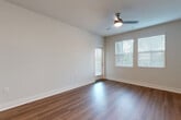 Located at 12406 Clark St in Moreno Valley, CA, this single-story, three-bedroom, one-bathroom home offers a thoughtfully designed layout with modern finishes throughout. The open living room features warm hardwood-style flooring, a ceiling fan, and large windows with blinds that allow ample natural light to fill the space. Adjacent to the living area, the combined dining room and kitchen is a standout feature, showcasing rich dark-toned cabinetry, white quartz countertops, a classic subway tile backsplash, and a full suite of stainless steel appliances including a gas range, microwave, and refrigerator. Light wood-style flooring ties the kitchen together with a clean, contemporary feel. The three bedrooms are carpeted for comfort, each offering closet space and natural light via window treatments. The primary bedroom is generously proportioned and provides direct access to the hallway. The full bathroom is well-appointed with a tub-shower combination, white tile surround, a dark vanity with dual sinks, and light wood-style flooring. A dedicated laundry area, hallway, and private balcony round out the functional layout of this well-maintained home.