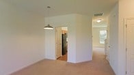 Located at 105 Still Run in Clayton, New Jersey, this two-story home offers a well-organized layout designed for comfortable everyday living. The main level features an open-concept living and dining area finished with soft, neutral-toned carpeting that creates a warm and inviting atmosphere. A pass-through opening connects seamlessly to the kitchen, which is equipped with stainless steel appliances, including a full-size refrigerator, and is complemented by warm wood-toned cabinetry and hard flooring — providing both style and practicality. A pendant light fixture anchors the dining area, adding a clean, modern touch to the space. Natural light filters in through windows visible from the living area, brightening the interior and enhancing the sense of openness. The white walls throughout the main level contribute to a bright, neutral palette that makes the space feel airy and easy to personalize. Ceiling-mounted vents suggest a central HVAC system for year-round climate control. The second floor extends the home's living capacity, accommodating additional bedrooms and living spaces. Overall, this home presents a functional and approachable design, well-suited for a variety of lifestyles.