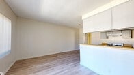 Located at 8541 Foothill Blvd in Los Angeles, CA, this one-bedroom, one-bathroom unit offers a practical and efficient single-level layout. The open-concept living and kitchen area serves as the heart of the home, where light wood-style laminate flooring extends throughout and a textured ceiling adds subtle character. A pass-through counter connects the living room to the galley-style kitchen, which features gray cabinetry on both sides, warm butcher block countertops, a gas range, and a stainless steel sink — providing a well-organized cooking space with generous storage. Vertical blinds on the living room window allow natural light to filter in while maintaining privacy, and a wall-mounted PTAC unit provides in-unit climate control. The bedroom is carpeted for comfort, benefits from its own window with vertical blinds, and includes a built-in sliding-door closet for convenient storage. The bathroom is clean and functional, offering a vanity with white cabinetry, a toilet, and a tub-shower combination enclosed with sliding glass doors. Wood-style flooring continues into the bathroom, maintaining a cohesive look throughout. A hallway connects the main living areas to the bedroom and bathroom, completing this efficiently designed unit.