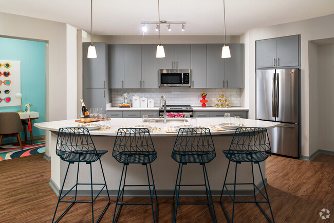 Kitchen with island and stainless steel appliances - The District at Rosemary