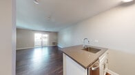 Located in the vibrant 92103 zip code of San Diego, California, this studio unit offers a thoughtfully designed single-floor layout that maximizes both comfort and functionality. Rich, dark hardwood flooring flows throughout the main living area, creating a warm and cohesive aesthetic that ties the space together.

The open-plan living area is bright and airy, benefiting from natural light that pours in through a sliding glass door leading to a private balcony — ideal for enjoying San Diego's renowned climate. A wall-mounted HVAC unit ensures year-round comfort.

The kitchen is well-appointed with a peninsula counter featuring a stainless steel sink and dark quartz-style countertops, white shaker cabinetry, a marble-patterned tile backsplash, and a full suite of stainless steel appliances including a refrigerator, electric range, and over-the-range microwave. Recessed lighting illuminates the kitchen area effectively.

The bathroom is clean and functional, featuring a combined shower and soaking tub, a white vanity with dark countertop, a large framed mirror, and coordinating hardwood-style flooring that maintains consistency with the rest of the unit.

Overall, this studio presents a modern, move-in-ready space with stylish finishes in a highly desirable San Diego neighborhood.