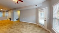 This efficiently designed 710-square-foot, single-floor apartment offers a well-organized layout encompassing one bedroom, one bathroom, a living room, kitchen, and a dedicated closet. The living room is bright and open, featuring light wood-look flooring, neutral gray walls, a ceiling fan, and multiple windows fitted with blinds that allow for ample natural light. A secondary entry door provides convenient exterior access directly from the living area. The kitchen is a standout feature, boasting dark gray cabinetry, granite countertops, and stainless steel appliances including a range, over-the-range microwave, and refrigerator — all combining for a modern, functional cooking space. The 150-square-foot bedroom is carpeted for comfort, includes a ceiling fan, and is served by a generously sized walk-in closet outfitted with wire shelving systems on multiple walls, offering substantial storage capacity. The bathroom features wood-look tile flooring, grab bars, and a clean, functional design. Throughout the unit, consistent gray-toned walls, white trim, and ceiling fans in each main room create a cohesive and comfortable living environment.