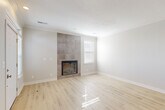 Located at 16610 Capitol Plaza in Omaha, Nebraska, this well-appointed single-story home offers 2 bedrooms and 3 bathrooms across a thoughtfully designed floor plan. Light-toned hardwood-style flooring runs throughout, complementing the neutral color palette and crown molding that lend a clean, modern aesthetic to the space.

The open-concept living and kitchen area forms the heart of the home. The kitchen features white shaker-style cabinetry, light stone countertops, stainless steel appliances including a range with microwave above and a full-size refrigerator, and a peninsula that flows seamlessly into the living area. The living room is anchored by a striking floor-to-ceiling tiled fireplace surround, adding a dramatic focal point, with a window allowing natural light to fill the space.

The generously sized primary bedroom offers a ceiling fan, multiple windows with blinds, and ample room to accommodate large furnishings. The second bedroom is bright and well-proportioned, also featuring natural light from a window. The three bathrooms provide added convenience, with clean, functional finishes throughout.

A dedicated laundry room houses a full-size washer and dryer set with overhead shelving for storage. A separate closet and hallway complete the layout, ensuring practical organization throughout the home.
