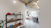 Located at 2000 North 2nd Street in Philadelphia's vibrant Northern Liberties neighborhood, this one-bedroom, one-bathroom unit showcases a compelling blend of industrial character and modern design. Exposed concrete ceilings with visible ductwork and bold accent piping define the aesthetic throughout, complemented by polished concrete floors that unify every room.

The open-plan living area flows seamlessly from a well-appointed kitchen featuring white upper cabinetry, gray lower cabinets, subway tile backsplash, stainless steel appliances, and a butcher block-topped island with bar seating — ideal for casual dining. Globe pendant lights add warmth against the raw concrete overhead.

The bedroom offers a serene retreat, highlighted by a dramatic full-height exposed concrete accent wall, a wall-mounted mini-split unit, and large windows that bring in natural light and city views. A closet and additional storage are conveniently accessible.

The bathroom is clean and modern, featuring a glass-enclosed walk-in shower with large-format tile, a sleek white floating vanity with ample drawer storage, and polished concrete flooring that maintains the cohesive material palette. A utility room and hallway with open shelving round out the well-organized layout, making efficient use of every square foot in this thoughtfully designed urban residence.