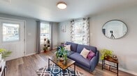Located at 1603 Roane St in Richmond, Virginia, this two-story, 2-bedroom, 1-bathroom home offers a well-organized and efficiently designed layout spread across two floors. The main floor features a bright and welcoming living room with large windows that allow generous natural light to fill the space, complemented by light hardwood-style flooring and soft gray walls throughout. The kitchen is thoughtfully updated with white cabinetry, granite countertops, stainless steel appliances including a range, microwave, dishwasher, and refrigerator, along with a window above the sink that adds to the airy feel. A hallway connects the main living areas to the rest of the home. Upstairs, the primary bedroom features vaulted ceilings, a closet, and a window with neighborhood views, creating a peaceful retreat. The second bedroom is also well-sized with natural light and closet storage. The shared bathroom includes a full tub and shower combination with clean white finishes. Consistent hardwood-style flooring and a neutral gray palette tie the entire home together, giving it a cohesive, modern, and move-in-ready aesthetic throughout both levels.