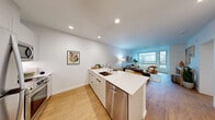Located at 821 S Washington St in Seattle's vibrant Pioneer Square neighborhood, this thoughtfully designed one-bedroom, one-bathroom residence offers a clean, modern aesthetic throughout. Light-toned hardwood flooring flows seamlessly across the open-concept main living area, connecting the kitchen, dining space, and living room in a cohesive and functional layout.

The kitchen is a standout feature, anchored by a generous white quartz island with bar seating for three. It is equipped with a full suite of stainless steel appliances, including a refrigerator, dishwasher, microwave, and range, all complemented by white cabinetry and a classic subway tile backsplash. The living room is bathed in natural light from large floor-to-ceiling windows that frame views of the surrounding Seattle skyline and greenery, with access to a private balcony.

The carpeted bedroom offers a comfortable retreat with its own window and dedicated closet. The bathroom features a wide white vanity with an undermount sink, a large mirror, and warm wood-toned flooring, delivering a clean and functional design. Recessed lighting throughout the home ensures a bright, welcoming ambiance. This well-appointed residence combines modern finishes with an efficient, livable floor plan in a prime Seattle location.