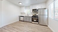 Located at 231 S Olive Ave in Alhambra, California, this single-floor unit offers a thoughtfully updated interior with a clean, modern aesthetic throughout. Light wood-tone flooring runs continuously across the living areas and bedroom, creating a cohesive and inviting atmosphere. The living room is bright and open, featuring a ceiling fan with integrated lighting and a wall-mounted air conditioning unit, with a front entry door and window that allow natural light to fill the space.

The kitchen is well-appointed with two-tone cabinetry — white upper cabinets and gray lower cabinets — complemented by light quartz countertops and a suite of stainless steel appliances, including a gas range, over-the-range microwave, dishwasher, and refrigerator. A window above the sink provides additional natural light, making the kitchen both functional and pleasant to work in.

The bedroom continues the warm flooring aesthetic and benefits from dual windows on adjacent walls, ensuring cross-ventilation and ample daylight. A ceiling fan with a light fixture adds comfort and practicality.

The bathroom is finished in a clean, all-white palette with subway tile surrounding the shower, a white vanity with brushed nickel fixtures, a large mirror, and a modern toilet. The overall design is minimal and fresh, reflecting a move-in ready condition throughout.