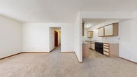 Located at 2949 W 24th Ave in Emporia, Kansas, this single-story home offers a practical and efficient layout across five bedrooms and two full bathrooms. The open living room features neutral carpet and flows directly into the kitchen area, which is partially separated by a half-wall with a breakfast bar overhang. The galley-style kitchen is well-equipped with abundant wood-trimmed cabinetry, white appliances including a range and refrigerator, a built-in dishwasher, and tile flooring. The bedrooms are carpeted and bright, with several featuring mirrored sliding-door closets and windows that allow natural light to fill the rooms. The primary bedroom includes a spacious walk-in closet outfitted with wire shelving and hanging rods for generous storage. The bathrooms feature tile flooring, vanities with under-sink cabinetry, and a tub-shower combination. A dedicated laundry room with tile flooring provides washer and dryer hookups along with additional wire shelving above. Consistent neutral tones, textured ceilings, and warm wood trim throughout give the home a cohesive, understated character suited for comfortable everyday living.