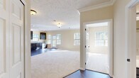 Located in Cranberry Township, PA, this single-story, three-bedroom, two-bathroom home offers a well-designed layout with a cohesive, neutral aesthetic throughout. The open living and dining area is anchored by rich hardwood-style flooring and abundant natural light streaming in through multiple windows, creating a bright and welcoming atmosphere. Crown molding adds a refined architectural touch to the main living space.

The kitchen is a standout feature, outfitted with dark espresso cabinetry, granite-look countertops, stainless steel appliances including a refrigerator, range, microwave, and dishwasher, and a dedicated pantry closet for additional storage. Hardwood-style flooring continues throughout the kitchen, which also benefits from recessed lighting and direct access to an outdoor deck area.

The bedrooms are finished with plush carpeting and receive ample natural light. The primary bedroom includes a walk-in closet with wire shelving, while secondary bedrooms feature standard closets with built-in rods. Both bathrooms are finished with dark cabinetry and white countertops; the primary bath offers a dual-sink vanity with a large mirror, while the second bath includes a tub/shower combination. The home also features an in-unit laundry area, completing this practical and comfortable layout.