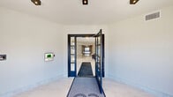 Located at 434 Springfield Ave in Berkeley Heights, NJ, this generously sized amenity floor offers a thoughtfully designed collection of shared spaces suited for both relaxation and social gatherings. The entry vestibule sets an elegant tone with sleek dark-framed glass doors, light tile flooring, and recessed lighting that draws residents into the interior.

The main lounge area features rich hardwood floors, large black-framed windows that allow abundant natural light, and a cozy fireplace anchoring the living space. An adjacent dining area offers a long communal table with contemporary seating, ideal for group gatherings or events. A dedicated billiards lounge is outfitted with a full-size pool table beneath a striking multi-arm chandelier, with oversized windows overlooking the streetscape.

A private screening room provides a true cinematic experience, complete with rows of plush leather reclining chairs with cup holders, patterned carpeting, wall sconces, and a large wall-mounted display. A quiet office space with warm wood flooring and minimalist furnishings rounds out the interior amenities.

Outside, a spacious courtyard plaza features wide-open paver areas, manicured planting beds, gas grills, and string lighting—all framed by the building's modern multi-story façade with private balconies.