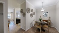 Located at Heron Pointe in Nashville, TN, this single-story, one-bedroom, two-bathroom home offers a well-organized layout across a comfortable footprint. The living room greets you with warm hardwood-style flooring, crown molding, and large windows alongside a glass-paneled exterior door that allows abundant natural light to fill the space. The adjacent dining area features the same flooring and crown molding detail, centered beneath a classic pendant light fixture. The kitchen is equipped with dark cabinetry, granite-style countertops, black appliances including a refrigerator, range, and microwave, and wood-look flooring that ties seamlessly into the main living areas. The generously sized primary bedroom is finished with plush carpeting, a ceiling fan, and a window that brings in natural light. It connects to a dedicated bathroom as well as a closet for ample storage. A second full bathroom features tile flooring and a tub-shower combination. Throughout the home, a neutral warm-gray color palette, crown molding, and clean white trim create a cohesive and polished aesthetic. The layout flows efficiently, making the most of every square foot in this well-appointed Nashville residence.