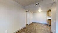 Located at 5220 W Northern Ave in Glendale, Arizona, this single-floor, one-bedroom, one-bathroom unit offers a practical and well-organized layout. The combined living, dining, and kitchen area forms the heart of the home, featuring wood-look laminate flooring, a ceiling fan, and a sliding glass door that opens to a private patio — bringing in natural light and outdoor access. The kitchen is equipped with warm-toned wood cabinetry, white countertops, a stainless steel sink, recessed lighting, and a black electric range, providing a functional cooking space. The bedroom features plush carpeting, a ceiling fan with light fixture, a window with blinds for natural light, and access to two closets for generous storage. The bathroom includes a full tub/shower combo with clean white surroundings and wood-look flooring. A dedicated in-unit laundry area accommodates a stacked washer and dryer, adding everyday convenience. Throughout the unit, textured ceilings, neutral wall tones, and consistent flooring create a cohesive and low-maintenance aesthetic. The hallway connects all rooms efficiently, making the most of the compact yet thoughtfully designed floor plan.
