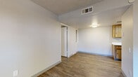 Located at 5220 W Northern Ave in Glendale, Arizona, this single-floor, one-bedroom, one-bathroom unit offers a practical and well-organized layout. The combined living, dining, and kitchen area forms the heart of the home, featuring wood-look laminate flooring, a ceiling fan, and a sliding glass door that opens to a private patio — bringing in natural light and outdoor access. The kitchen is equipped with warm-toned wood cabinetry, white countertops, a stainless steel sink, recessed lighting, and a black electric range, providing a functional cooking space. The bedroom features plush carpeting, a ceiling fan with light fixture, a window with blinds for natural light, and access to two closets for generous storage. The bathroom includes a full tub/shower combo with clean white surroundings and wood-look flooring. A dedicated in-unit laundry area accommodates a stacked washer and dryer, adding everyday convenience. Throughout the unit, textured ceilings, neutral wall tones, and consistent flooring create a cohesive and low-maintenance aesthetic. The hallway connects all rooms efficiently, making the most of the compact yet thoughtfully designed floor plan.