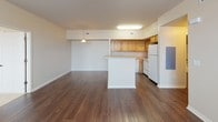This single-story residence offers a well-organized layout with distinct living, sleeping, and utility areas. The open-concept living and dining space is anchored by rich, dark hardwood-style flooring and features a ceiling fan, large windows that invite natural light, and direct sightlines into the kitchen. A breakfast bar peninsula separates the two areas, providing both additional counter space and a casual dining option.

The kitchen is outfitted with warm honey-toned wood cabinetry, light countertops, and white appliances including a refrigerator, electric range, and dishwasher. An under-cabinet light above the range provides focused task lighting, and the layout allows for efficient movement throughout the space.

The bedrooms are carpeted and generously proportioned, each equipped with a ceiling fan and large windows fitted with horizontal blinds. The primary bedroom connects to a spacious walk-in closet with multiple hanging rods and shelving, maximizing storage capacity.

Two bathrooms serve the residence. The primary bath includes a vanity with wood cabinetry, a framed mirror, and a full tub-shower combination. The secondary bathroom features dark hardwood-style flooring, overhead cabinetry, and a shower area. Both bathrooms are functional and well-appointed throughout.