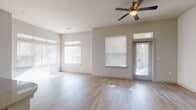 Located on Violet Crown Lane in Austin, TX 78741, this single-story residence offers a well-designed open-concept floor plan with modern finishes throughout. The spacious living area features warm wood-look flooring, vaulted ceilings with a ceiling fan, and an abundance of natural light streaming through multiple large windows fitted with blinds. A glass-paneled front door further enhances the bright, airy atmosphere.

The kitchen is a standout feature, showcasing rich dark cabinetry that extends to the ceiling, granite countertops, a classic white subway tile backsplash, and a full suite of stainless steel appliances including a range, microwave, and refrigerator. A central island with a granite top and built-in sink, accented by pendant lighting, provides both workspace and a visual focal point that connects seamlessly to the living area.

The bedrooms are generously sized with plush carpeting and natural light provided by individual windows. The bathrooms are finished with large-format marble-look porcelain tile flooring, dark vanity cabinetry, and well-lit mirrors. One bathroom includes a soaking tub and a dedicated walk-in closet with built-in shelving, adding practical storage and comfort to the private quarters.