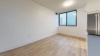 Located at 300 Antibes Dr in Toronto's North York neighbourhood, this well-appointed 3-bedroom, 1-bathroom unit offers a thoughtfully designed layout across a single floor. Light-toned hardwood-style flooring runs throughout the entire space, creating a cohesive and contemporary feel.

The kitchen is outfitted with crisp white shaker-style cabinetry, dark countertops, a classic subway tile backsplash, a stainless steel double sink, and a dishwasher — combining both style and functionality. The open living area provides a bright, airy atmosphere with clean white walls and ample room for a variety of furniture arrangements.

The generously sized primary bedroom is the largest of the three, offering substantial space and access to natural light. All three bedrooms feature large windows that frame elevated city views of the Toronto skyline and surrounding urban landscape. One bedroom includes a full-wall mirrored sliding closet, adding both storage and a sense of depth to the room.

The bathroom is finished with white subway tile surrounding a soaking bathtub with an overhead shower, paired with a modern vanity and neutral stone-toned floor tiles, creating a clean and timeless aesthetic.

Throughout the unit, bright white walls, consistent flooring, and abundant natural light from multiple exposures contribute to a fresh, move-in-ready environment.