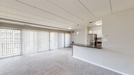 Located at 2907 Fallstaff Road in Baltimore, this one-bedroom, one-bathroom unit offers a well-organized single-floor layout designed to maximize functionality. The combined kitchen and living area forms the heart of the space, where light-toned carpeting extends throughout the living zone, and large sliding glass doors fitted with vertical blinds allow generous natural light and outdoor views to define the room's ambiance.

The kitchen is notably well-appointed, featuring two-toned cabinetry—white upper cabinets paired with gray lower cabinets—granite countertops, a herringbone-pattern tile backsplash, stainless steel appliances including a gas range with a wall-mounted hood, refrigerator, and dishwasher, and light wood-look flooring. A peninsula counter with pendant lighting provides additional workspace and visually separates the kitchen from the living area.

The bedroom is a comfortably sized room with carpet flooring, a large window offering outdoor tree views, and a built-in closet with louvered bifold doors and multi-shelf storage. The bathroom includes a full tub-shower combination with white tile surround. A hallway connects the rooms and provides additional storage access, contributing to the unit's efficient and practical overall layout.
