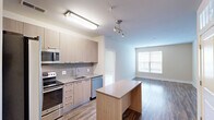 Located at 650 Shillings St in Alexandria, VA, this well-designed two-bedroom, two-bathroom unit offers a modern and functional layout across a single floor. The open-concept kitchen seamlessly connects to the living area, creating a cohesive and inviting space. The kitchen is outfitted with stainless steel appliances — including a French door refrigerator, electric range, built-in microwave, and dishwasher — complemented by light wood cabinetry, a tile mosaic backsplash, and a central island with built-in shelving that provides additional prep and storage space. Hardwood-style flooring runs throughout the main living areas, adding warmth and continuity.

The living room benefits from a large window that draws in natural light and offers views of the surrounding community. Both bedrooms feature plush carpeting and their own windows, with the primary bedroom including a dedicated walk-in closet. Each bathroom is finished with tile flooring, a white vanity with ample drawer storage, a framed mirror, and contemporary fixtures. An in-unit washer and dryer add everyday convenience. The neutral color palette throughout creates a clean, modern ambiance well-suited for comfortable living in the heart of Alexandria.