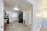 Located at 1817 Burnet Ave in Syracuse, NY, this 2-bedroom, 1-bathroom single-floor home offers a practical and comfortable layout with thoughtfully updated finishes throughout. The kitchen is a standout feature, outfitted with rich cherry wood cabinetry, granite-style countertops, a gray subway tile backsplash, and black appliances including a gas range, microwave, and refrigerator. Light luxury vinyl plank flooring runs through the kitchen and extends into the adjoining dining and living areas, creating a cohesive, easy-to-maintain space. Natural light filters in through multiple windows, brightening the open flow between the kitchen and living room. The primary bedroom features warm hardwood floors, two windows with outdoor views, and a baseboard heating system. The second bedroom also showcases hardwood flooring and includes a mirrored sliding closet door, adding depth and brightness to the room. Three closets throughout the home provide ample storage. The bathroom is cleanly finished with a modern vanity, stone-top countertop, undermount sink, brushed nickel fixtures, and a large wall mirror. The neutral color palette and clean lines throughout give the home a tidy, move-in-ready character well-suited for comfortable everyday living.