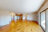Located at Stone Gate Heights in Jamesville, NY, this well-appointed two-bedroom, two-bathroom residence offers a practical and comfortable single-floor layout. The open-concept living and dining area is anchored by warm honey-toned hardwood flooring that flows throughout the main living spaces, creating a bright and cohesive feel. Large sliding glass doors lead to a private balcony with outdoor views of the surrounding tree-lined neighborhood, filling the living area with natural light.

The kitchen features warm wood cabinetry, ample upper and lower cabinet storage, a double-basin stainless steel sink, and a full suite of white appliances, all set on a continuous countertop workspace. The space opens naturally toward the living area, supporting an easy flow for daily living and entertaining.

Both bedrooms are carpeted for comfort and include generous closet space, with large bifold or sliding closet doors providing excellent storage. The primary bedroom is particularly spacious. The two bathrooms are finished with tile flooring and include a full tub-and-shower combination with a wood-toned vanity. Additional storage is provided by five closets distributed throughout the unit. Baseboard heating serves the living spaces, and a wall-mounted AC unit ensures year-round comfort.