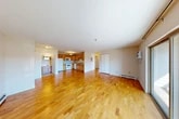 Located at Stone Gate Heights in Jamesville, NY, this well-appointed two-bedroom, two-bathroom residence offers a practical and comfortable single-floor layout. The open-concept living and dining area is anchored by warm honey-toned hardwood flooring that flows throughout the main living spaces, creating a bright and cohesive feel. Large sliding glass doors lead to a private balcony with outdoor views of the surrounding tree-lined neighborhood, filling the living area with natural light.

The kitchen features warm wood cabinetry, ample upper and lower cabinet storage, a double-basin stainless steel sink, and a full suite of white appliances, all set on a continuous countertop workspace. The space opens naturally toward the living area, supporting an easy flow for daily living and entertaining.

Both bedrooms are carpeted for comfort and include generous closet space, with large bifold or sliding closet doors providing excellent storage. The primary bedroom is particularly spacious. The two bathrooms are finished with tile flooring and include a full tub-and-shower combination with a wood-toned vanity. Additional storage is provided by five closets distributed throughout the unit. Baseboard heating serves the living spaces, and a wall-mounted AC unit ensures year-round comfort.