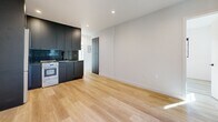 Located at 225 Lucas Ave in the heart of Los Angeles, this modern 3-bedroom, 2-bathroom unit delivers a clean, contemporary aesthetic across a well-organized single-floor layout. Light wood-style flooring runs throughout, complementing crisp white walls and bold black-framed windows and doors that lend a sharp, modern contrast.

The open living and kitchen area serves as the social hub of the space. The kitchen features floor-to-ceiling matte black cabinetry, a black sink with matching fixtures, recessed lighting, and stainless steel appliances — a striking design statement. The adjacent living area benefits from a full-height sliding glass door that opens to an outdoor area with lush greenery, allowing generous natural light to pour in. A wall-mounted mini-split system ensures year-round comfort.

Three well-proportioned bedrooms each feature black-framed windows with neighborhood views and ample natural light. The primary bedroom stands out with a mirrored sliding closet and an additional sliding glass door leading to a private outdoor space.

The bathrooms are finished in a clean, all-white palette. One features a frameless glass-enclosed walk-in shower with a built-in niche, a rain showerhead, and a frosted window for natural light — delivering a spa-like feel. The overall ambiance is bright, minimal, and move-in ready.