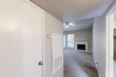 Located at 14000 Ella Blvd in Houston, Texas, this 2-bedroom, 2-bathroom residence offers a practical and comfortable single-floor layout. The entrance leads into a spacious living room featuring vaulted ceilings, a ceiling fan, and a white-mantled fireplace, creating a warm and inviting focal point. A pass-through window connects the living area to the kitchen, enhancing the sense of openness and making everyday interactions between spaces effortless. Soft carpet flooring extends throughout the living and bedroom areas, adding a cozy feel underfoot. The primary bedroom is generously sized, benefiting from natural light through a large window with outdoor views, and is equipped with a ceiling fan and dedicated closet space. The second bedroom mirrors a similar layout, also featuring a ceiling fan and access to a closet. Both bathrooms are clean and functional, each fitted with a full tub-shower combo with white tile surround. One bathroom features wood-style flooring and a vanity with a stone-look countertop. Ceiling fans are present in every major room, ensuring year-round comfort. The overall ambiance is neutral and bright, with light gray walls and white trim providing a clean, move-in-ready aesthetic throughout.