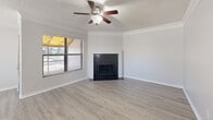 Located in Clearwater, FL, this single-story 2-bedroom, 1-bathroom unit offers a well-organized layout across a comfortable floor plan. The living room serves as the heart of the home, featuring light wood-look laminate flooring, crown molding, a textured ceiling with a ceiling fan, and a striking black tile fireplace as a focal point. A large window allows natural light to fill the space and provides views of the surrounding area.

The kitchen is thoughtfully designed with dark navy cabinetry, light countertops, and a suite of appliances including a stainless refrigerator, electric range, built-in microwave, and dishwasher. Light wood-look flooring continues here, and a window above the sink provides additional natural light.

Both bedrooms are carpeted and feature ceiling fans and textured ceilings. The primary bedroom offers ample room and access to a dedicated closet with louvered doors. The second bedroom benefits from dual windows on a corner wall, filling the space with abundant natural light and outdoor views of mature trees.

The bathroom includes a full tub/shower combination with clean white tile surround and chrome fixtures. Throughout the unit, consistent use of light, neutral tones and clean finishes creates a cohesive and functional living environment.