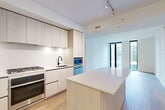 Located at 1320 4th St NE in Washington, DC, this modern 2-bedroom, 2-bathroom residence offers a thoughtfully designed single-level layout with clean contemporary finishes throughout. Light wood flooring flows seamlessly across the living spaces, complementing the bright white walls and creating a cohesive, airy aesthetic.

The open-concept kitchen is a standout feature, outfitted with light wood flat-front cabinetry extending to the ceiling, stainless steel appliances including a gas range and wall oven, a sleek undermount sink, and a generous center island with a quartz countertop — ideal for both meal prep and casual dining. The kitchen opens directly into the combined dining and living area, which is bathed in natural light through dramatic floor-to-ceiling black-framed windows offering views of the surrounding cityscape.

Both bedrooms are well-proportioned and bright, each featuring large windows that frame urban views. The bathrooms are finished with hexagonal tile flooring, white subway tile surrounds, and matte black fixtures and hardware. Additional conveniences include dedicated laundry, a utility room, multiple closets, and a hallway connecting all spaces efficiently. The overall design emphasizes minimalism, functionality, and modern urban living.