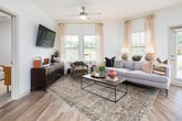This single-floor residence offers a thoughtfully designed open-concept layout that seamlessly connects the kitchen, dining, and living areas. The kitchen is a functional centerpiece, equipped with stainless steel appliances including a refrigerator, microwave, and range, complemented by rich dark cabinetry, granite countertops, and a kitchen island with seating for casual dining. Pendant lighting and open shelving add both style and practicality, while large windows invite abundant natural light.

The living area provides a comfortable and versatile space, featuring wood-look flooring, a ceiling fan, and windows that offer views of the surrounding greenery. Natural light flows generously throughout, enhancing the bright, airy atmosphere of the home.

The residence includes multiple bedrooms, each carpeted for comfort and equipped with windows that allow natural light to filter in. One bedroom features a distinctive accent wall, adding a bold design element to the space.

The bathrooms are well-appointed with granite vanity countertops, dark cabinetry with brushed hardware, and wood-look flooring. One bathroom includes a tub-shower combination, while another features a vanity with a large mirror and pendant lighting. A corridor with a built-in desk area provides a convenient home office nook, rounding out this functional and stylish residence.