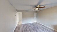 Located at 1426 Burgess Dr in Dalton, GA, this single-story, one-bedroom, one-bathroom home offers an efficient and practical layout across a well-utilized floor plan. Neutral warm-gray walls and consistent light vinyl plank flooring flow throughout the main living areas, creating a clean and cohesive aesthetic. The living room is bright and open, featuring a ceiling fan with light fixture and a window that invites natural light, with direct access to the entry door. The kitchen is well-equipped, showcasing dark cabinetry with ample upper and lower storage, a mosaic tile backsplash, light countertops, and a full suite of appliances including a refrigerator, electric range, microwave, and dishwasher. Overhead fluorescent lighting ensures the kitchen is well-lit for everyday use. The bedroom is comfortably sized with plush carpeting, a ceiling fan, a window with blinds for natural light, and access to a dedicated closet with built-in shelving. A separate closet area off the main hall provides additional storage and includes connections for a washer and dryer. The bathroom features a full tub-and-shower combination with a curtain rod. Throughout the home, clean white trim and paneled doors maintain a tidy, consistent finish.