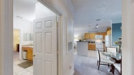 Located at 10300 Pine Lakes Ct in Raleigh, NC, this well-appointed one-bedroom, one-bathroom residence offers a thoughtfully designed single-floor layout. The open-concept living area is bright and inviting, featuring crown molding, plush carpeting, a ceiling fan, and a sliding glass door that leads to a private balcony with outdoor views — ideal for relaxing or entertaining. Adjacent to the living space, a dedicated dining area with blue accent walls adds a touch of character to the home. The kitchen is fully equipped with warm maple cabinetry, dark granite-style countertops, tile flooring, a full suite of white appliances including a dishwasher, electric range, microwave, and refrigerator, along with track lighting overhead. A dedicated in-unit laundry area accommodates a full-size washer and dryer with overhead shelving for added convenience. The bedroom is a comfortable retreat, featuring large windows that allow ample natural light, a ceiling fan, and direct outdoor views. The full bathroom includes a wood-toned vanity with a granite-style countertop, tile flooring, and a separate tub area. A closet completes the unit's practical storage offerings.