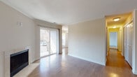 This single-floor residence offers a thoughtfully designed layout that balances comfort and functionality. The living area is a standout space, featuring warm hardwood-style flooring, elegant crown molding, and a tile-surround fireplace that serves as a natural focal point. A large sliding glass door floods the room with natural light and provides direct access to an outdoor patio, offering pleasant exterior views. Crown molding details add a refined architectural touch throughout the living and dining areas.

The galley-style kitchen is efficiently laid out with rich warm-toned wood cabinetry, granite countertops, and stainless steel appliances including a range, microwave, and refrigerator. The hardwood-style flooring continues seamlessly through the kitchen, lending a cohesive feel to the space.

The bedrooms are generously sized, featuring plush carpeting and large windows that invite ample natural light. The primary bedroom benefits from an en-suite bathroom with a granite-topped vanity, a large mirror, and access to a walk-in closet. A full bathroom with a tub-shower combination, wood-toned vanity, and hardwood-style flooring serves the additional bedrooms. Overall, the space presents a clean, neutral palette throughout, creating a bright and welcoming atmosphere.