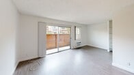 Located at 20939 Parthenia St in Canoga Park, CA, this one-bedroom, two-bathroom unit offers a thoughtfully designed, single-floor layout that maximizes every square foot. The open-concept living and dining area is anchored by wide sliding glass doors that lead to a private patio, filling the space with natural light and providing views of the surrounding outdoor area. Light wood-look flooring runs throughout, complementing the clean white walls and textured ceilings to create a bright, airy ambiance. A wall-mounted HVAC unit ensures year-round comfort in the living area. The kitchen features a peninsula countertop with white cabinetry, a refrigerator, and a range, opening directly to the living space for a connected, functional flow. The spacious bedroom includes built-in open shelving and a dedicated closet, providing ample storage options. The two bathrooms are finished in a clean, neutral palette, with one featuring a wide vanity countertop, white cabinetry, a large mirror, and a shower-tub combination. The overall aesthetic is clean and minimal, making it a versatile and practical space located in the heart of the San Fernando Valley.
