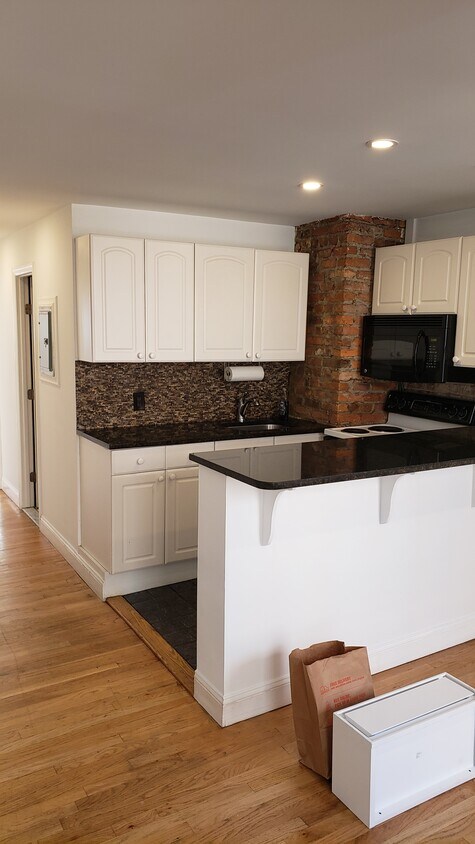 Kitchen with bar open to sunny, large dining/ living room - 234 S 2nd St