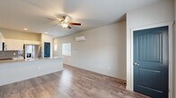 Located in Colorado Springs, CO, this efficiently designed one-bedroom, one-bathroom unit offers a thoughtful single-floor layout that maximizes every square foot. The open-concept living and kitchen area forms the heart of the home, anchored by wood-look plank flooring, a ceiling fan with light fixture, and a wall-mounted mini-split HVAC unit for year-round climate control. Natural light filters in through blinded windows, lending a bright and airy feel to the space.

The kitchen is a standout feature, showcasing crisp white cabinetry, a grey subway tile backsplash, granite-style countertops, and a peninsula with an undermount sink — ideal for casual dining or meal prep. Stainless steel appliances, including a refrigerator with ice maker, electric range, over-the-range microwave, and dishwasher, complete this modern culinary space.

The bedroom offers plush carpeting, a walk-in closet with built-in rod, a window with natural light, and a wall-mounted mini-split unit. Distinctive teal-painted arched doors add a charming design accent throughout the unit.

The bathroom includes a full tub-shower combination and a granite-topped vanity. A stacked washer and dryer unit is conveniently housed within the bathroom, providing in-unit laundry. This unit delivers practical, modern living in a clean, contemporary package.