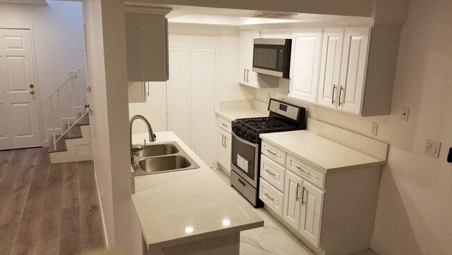 Kitchen with quartz countertops and appliances - 14126 Tiara St