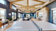 Located in Frisco, TX, this single-floor amenity facility offers a thoughtfully designed space built for recreation and relaxation. The interior showcases a modern farmhouse aesthetic highlighted by exposed wood beam trusses, light hardwood flooring throughout, and a striking combination of crisp white and deep navy shiplap wall paneling.

The space is anchored by a state-of-the-art indoor golf simulator room, complete with a projector, hitting mat, and built-in cabinetry — ideal for year-round play. Adjacent areas include an open game room featuring a basketball arcade unit and a ping pong table, providing additional entertainment options.

A welcoming lounge area offers comfortable seating, wall-mounted displays, and a well-appointed wet bar with a beverage refrigerator and ample counter space. Soaring vaulted ceilings and oversized windows flood the interior with natural light, while clerestory windows in the game room zone add even more brightness and visual height.

Multiple sets of glass French doors open to an outdoor patio, seamlessly connecting the interior to the surrounding landscape. Recessed lighting, stylish flush-mount and pendant fixtures, and exposed ductwork in select areas contribute to the space's contemporary yet inviting character, making it a well-rounded amenity hub for the community.
