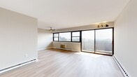 This two-bedroom, one-bathroom unit in Philadelphia's 19131 zip code offers a well-organized layout filled with natural light and clean, modern finishes throughout. The open living room is a standout space, featuring light hardwood flooring, a ceiling fan, and an expansive wall of large black-framed windows paired with a sliding glass door that opens onto a private balcony. From here, sweeping elevated views of the Philadelphia skyline and surrounding neighborhoods create a bright, airy atmosphere. Baseboard heating runs throughout the unit, ensuring consistent comfort year-round. The kitchen is thoughtfully appointed with white shaker cabinetry, a white subway tile backsplash, light countertops, and a full suite of stainless steel appliances including a refrigerator, electric range, built-in microwave, and dishwasher. The primary bedroom is generously sized, offering a large closet, its own window with city views, and a ceiling fan. The second bedroom receives ample natural light. The full bathroom features a tiled shower-tub combination, a white vanity with storage, and neutral tile flooring. A dedicated closet provides additional storage. Light hardwood-style flooring flows consistently throughout the entire unit, enhancing the cohesive and contemporary feel of the space.