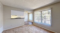 Located at 450 N Soldano Ave in Azusa, CA, this single-floor residence offers a well-organized layout with one bedroom and two full bathrooms. The living room features plush carpet flooring, a ceiling fan, and a textured ceiling, with large sliding glass doors framed by vertical blinds that flood the space with natural light and provide direct access to a private balcony overlooking greenery. The galley-style kitchen is efficiently designed with white cabinetry, dark countertops, a double sink, electric range, dishwasher, and a bright skylight-style ceiling panel overhead. Wood-style flooring runs throughout the kitchen and bathrooms, adding warmth and visual contrast. The combined dining and kitchen area flows naturally from the main living space. The bedroom is a comfortable, carpeted retreat featuring a window with vertical blinds and direct access to a hallway connecting to the bathrooms. A dedicated closet and pantry provide ample storage. The bathrooms include a tub/shower combination with clean white surrounds and wood-look flooring. A hallway connects the bedroom to the bathrooms and pantry, maintaining a logical and accessible flow throughout the home. This unit offers a clean, functional living environment suited for everyday comfort.