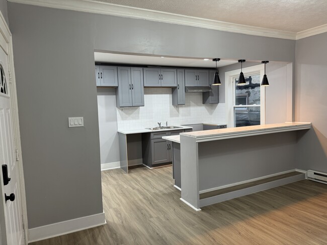 Open Concept Kitchen & Dining Area- Modern open kitchen with bar seating, ideal for entertaining. - 898-902 Portland Ave