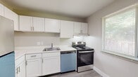 Located at 629 Hay Mac Dr in Parchment, Michigan, this single-floor unit presents a clean, updated interior with a neutral color palette and a straightforward layout designed for comfortable everyday living. The living area is generously sized, featuring light wood-look luxury vinyl plank flooring, soft gray walls, and wall-mounted accent lighting that adds a warm touch. A pass-through window connects the living space directly to the kitchen, enhancing the open feel between rooms.

The kitchen is well-appointed with white shaker-style cabinetry extending to the upper and lower walls, light-toned countertops, a stainless steel single-basin sink, a stainless steel electric range, and a dishwasher. A window positioned beside the range brings in natural light, making the space feel bright and functional.

The bedrooms are carpeted in a neutral tan tone and each feature windows with blinds, offering views of surrounding greenery. The bathroom includes a full tub and shower combination, wood-look vinyl flooring, and clean, minimal fixtures.

Throughout the unit, consistent use of light tones, updated flooring, and ample natural light contribute to a cohesive and welcoming atmosphere.
